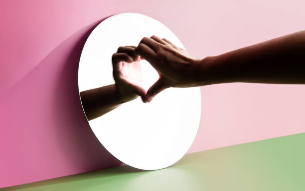 Conceptual Photo for Love and Relationship. Love Yourself. Single Person using Hand to Form a Heart Shape on the Mirror. Fill Yourself with Romance on Valentines Day stock photo