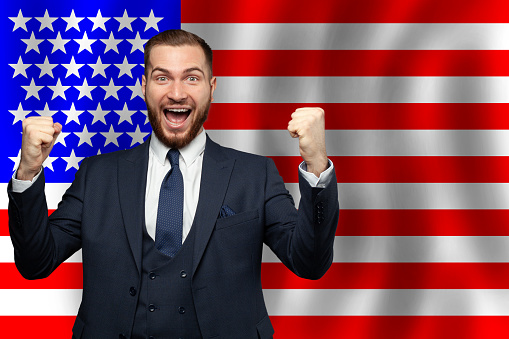 American happy businessman on the background of flag of USA Business, education, degree and citizenship concept