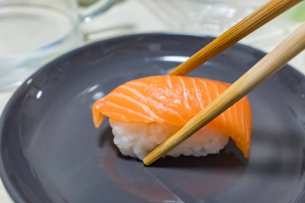 Salmon sushi by wooden chopsticks
