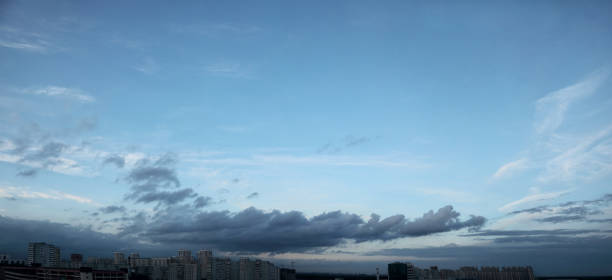 istock Blue sky panorama with clouds over tops of buildings 1460433240