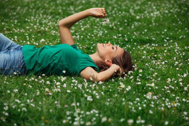 istock Smiling young woman lying on grass 1460434213