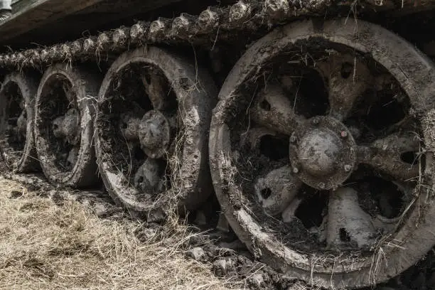 Caterpillar continuous track on army battle tank, military tracked vehicle on a battlefield.