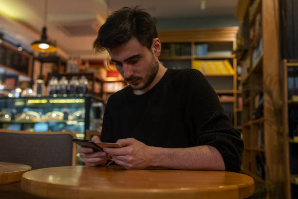 istock young man using his credit card to pay on his cell phone 1460445713