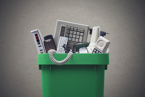 Waste bin full of electronics, e-waste and recycling concept