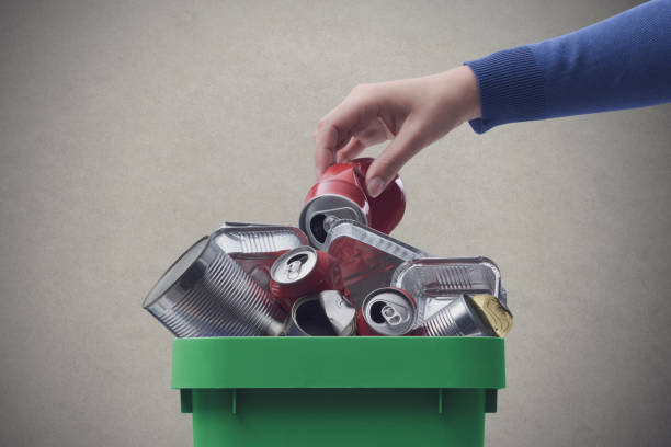 istock Woman throwing a can in the recycling bin 1460446713
