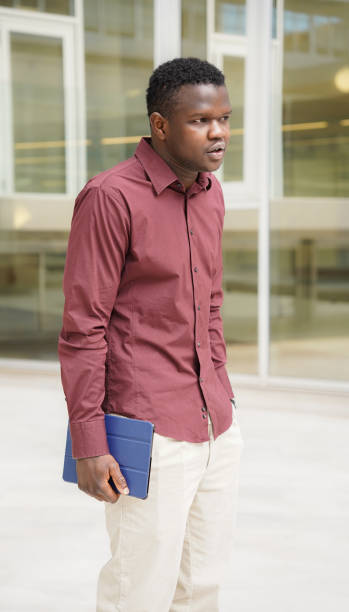 istock Executive African man outside the office with a laptop in hand. Migrated people working 1460447721