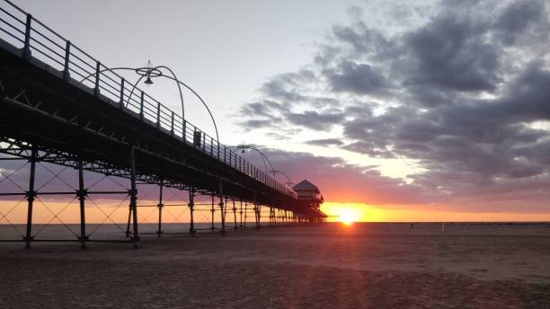 istock Beautiful sunset scene at a beach with a pier and a lifeguard tower 1460448122