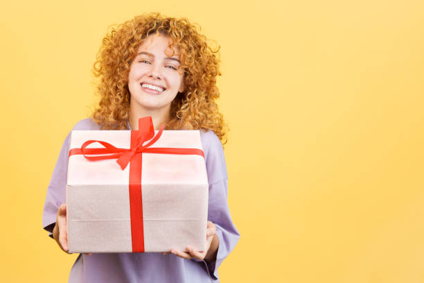 istock Happy woman smiling at camera while giving a gift 1460448215