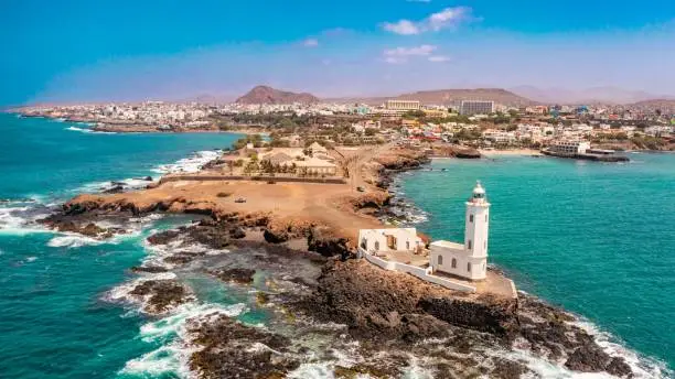 An aerial view of the shore of Praia de Santiago and the Praia lighthouse on a sunny day