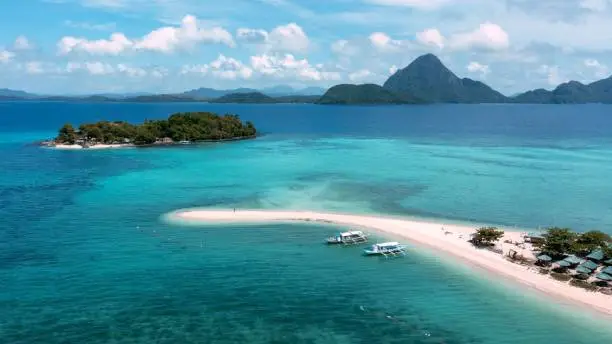 An aerial view of a beautiful white-sand beach island and crystal-clear waters