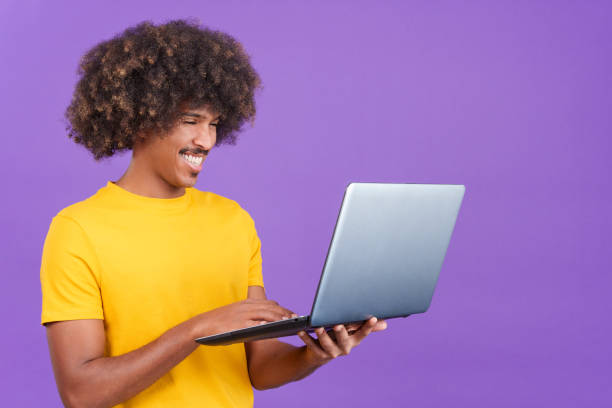 istock Happy african man standing and using a laptop 1460449300