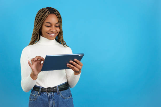 istock Smiling african woman using a digital tablet 1460449499