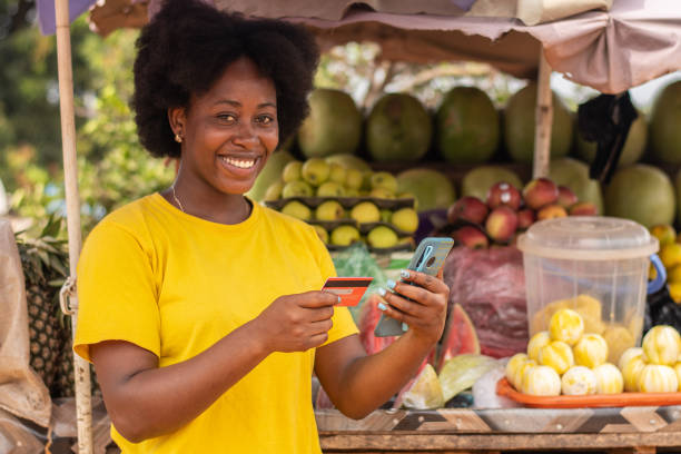 istock Smiling African lady using her credit card and phone 1460452675