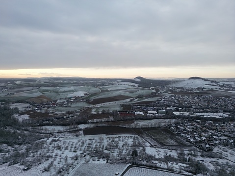 An aerial view of a snow covered village in rural landscape