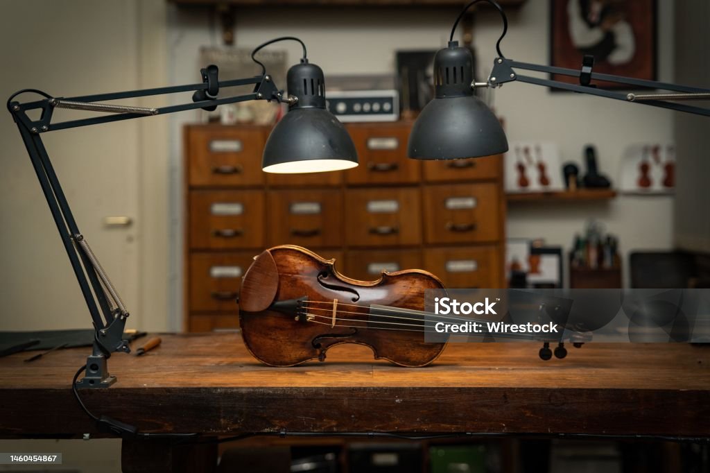 Violin On Wooden Table The Lamps After The Luthiery On The Workshop Photo - Download Image Now iStock
