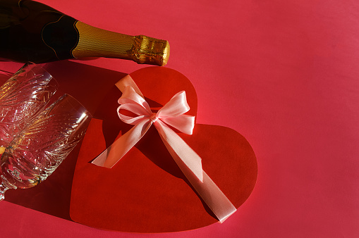 Valentine's day. holiday of lovers, love. viva magenta. bright background for decoration. a heart, a bottle of champagne and glasses for a drink. The 14th of February.