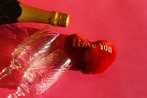 Valentine's day. holiday of lovers, love. viva magenta. bright background for decoration. a heart, a bottle of champagne and glasses for a drink. The 14th of February.