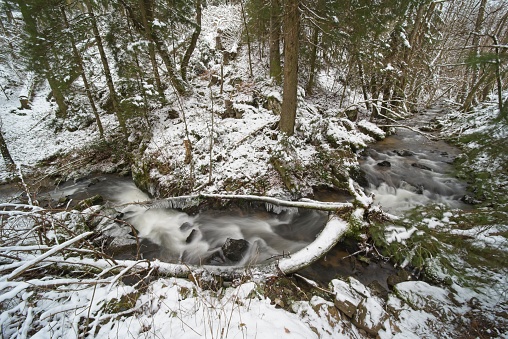 long exposure in the wintry forest by a creek