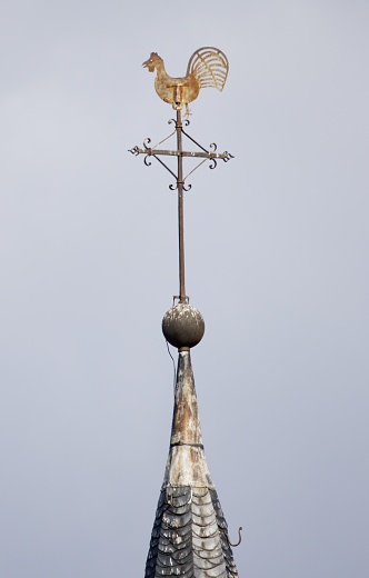 A vertical shot of the  wind vane detail of the Catholic Parish Church of St. Laurentius Wetterhahn