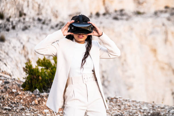 istock Elegant woman dressed in a white suit using a virtual reality goggles 1460456301