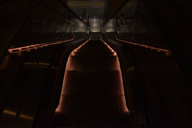 istock Low angle shot of an escalator with dim lights 1460456528