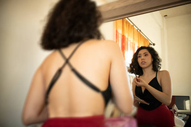 istock Young Hispanic female applying makeup in front of a mirror 1460457363