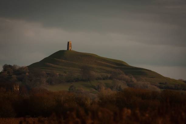 istock Glastonbury Tor from afar through Ham Wall Nature Reserve against a dark cloudy sky 1460460645