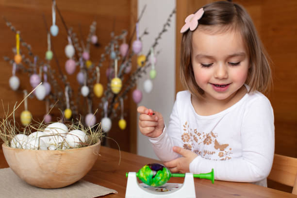 istock Happy toddler girl coloring eggs for Easter celebration 1460461671