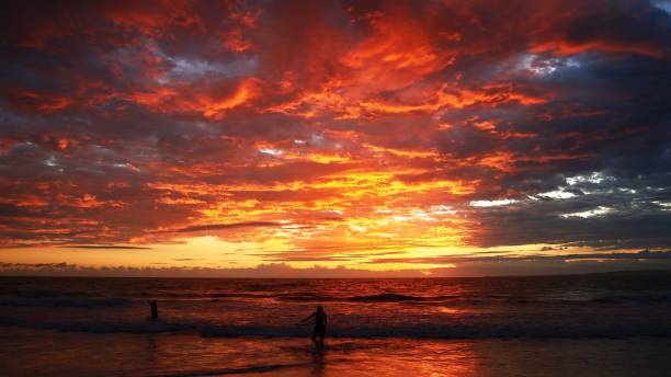 istock Cloudy sky glowing orange and red during sunset above the beautiful sea 1460463101