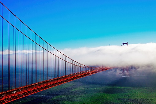 Dense sea fog covering the Golden Gate Bridge on a sunny day, San Francisco, USA