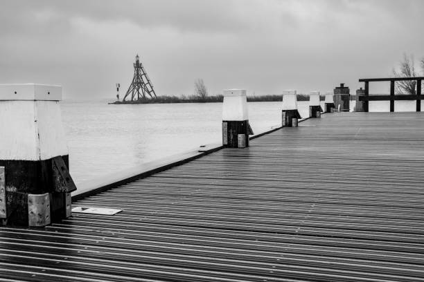 Aerial view of a jetty with bollards in black and white in the Netherlands An aerial view of a jetty with bollards in black and white in the Netherlands bollard pier water lake stock pictures, royalty-free photos & images