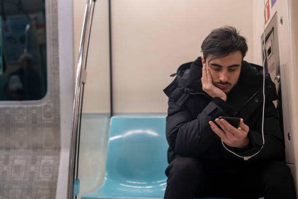 istock young man looking  to his smart phone in the subway train 1460466321