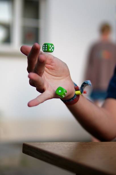 istock Vertical shot of a person rolling green dice 1460466716