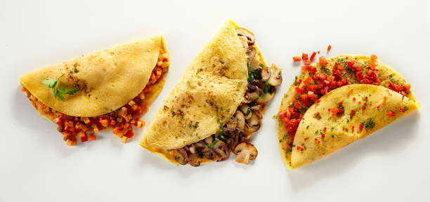 istock Assorted vegetarian omelets with mushrooms and vegetables, arranged in a row on a white table 1460468349