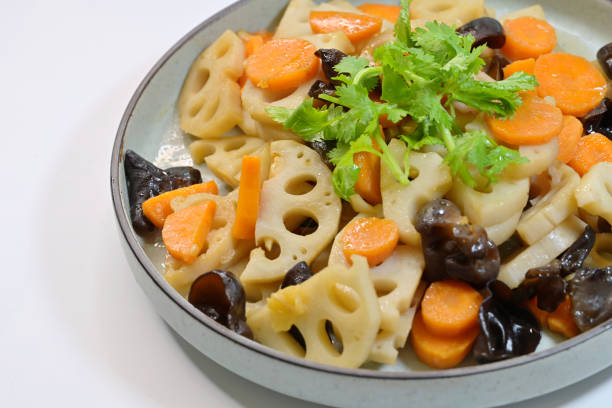 home-cooked dish of stir-fried lotus roots, carrots, wood ear fungus, garnished with chinese parsley - fungus roots imagens e fotografias de stock