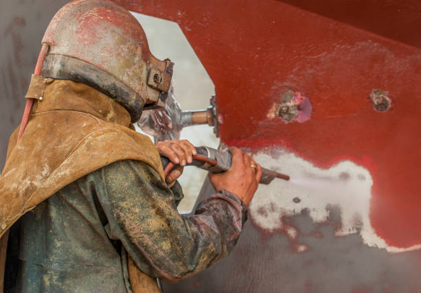 istock worker, sandblasting the corroded hull of a  boat 1460469219