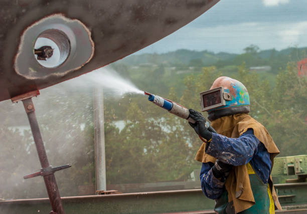istock worker, sandblasting the corroded hull of a  boat 1460469301