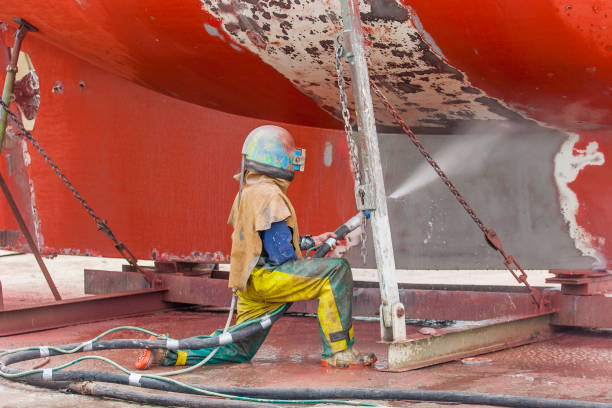 istock worker, sandblasting the corroded hull of a  boat 1460469343