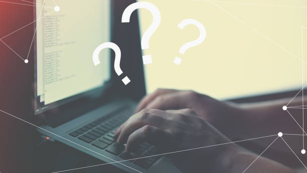 istock Closeup of a person solving a problem on the laptop with illustrative question marks on it 1460471247