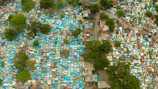 Famous cemetery in the city of Manila, where people live among the graves and crypts top view. Travel concept.