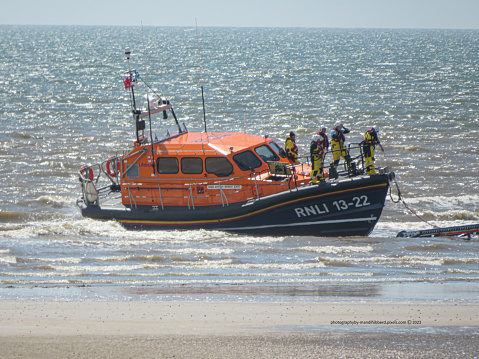 Bridlington RNLI Lifeboat 13-22 on the beach and the crew have attached the tether to haul the lifeboat onto the Caterpillar Retrival and Launch Tractor and taken back to the Station have Lifeboat Crew Training out in the North Sea.  Photograph taken from the beach.