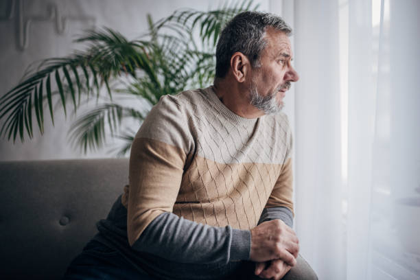 istock Depressed old man sitting alone at home 1460473708