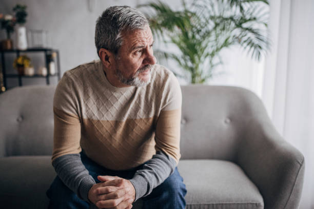 istock Depressed old man sitting alone at home 1460473736