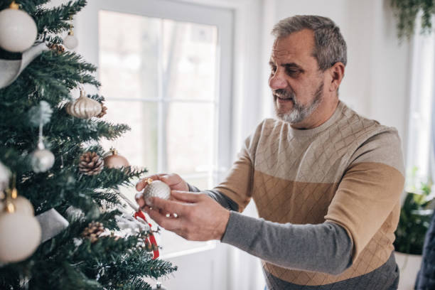 istock Senior decorates the Christmas tree by himself 1460475304