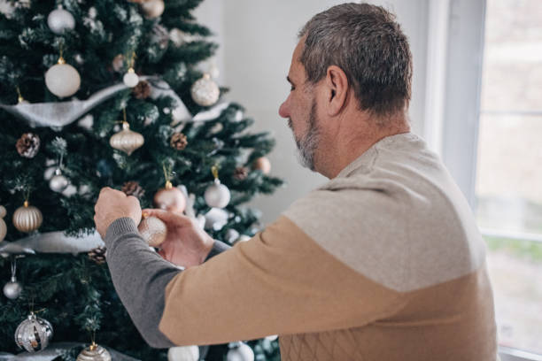istock Senior decorates the Christmas tree by himself 1460475369