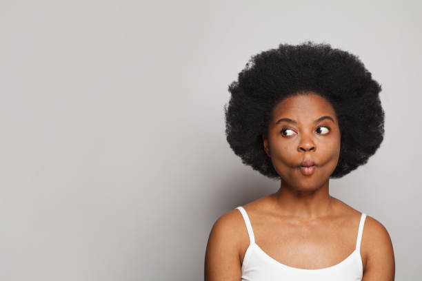 istock Pretty woman grimacing. Funny face on grey background 1460476985