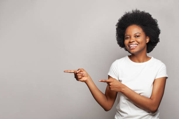 istock Happy nice brunette woman pointing finger on white studio wall banner background with copy space 1460477019