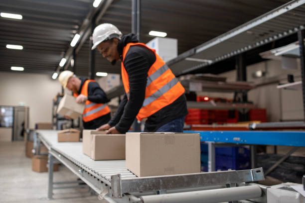 istock Two male warehouse workers on a packing and delivery production line 1460477961