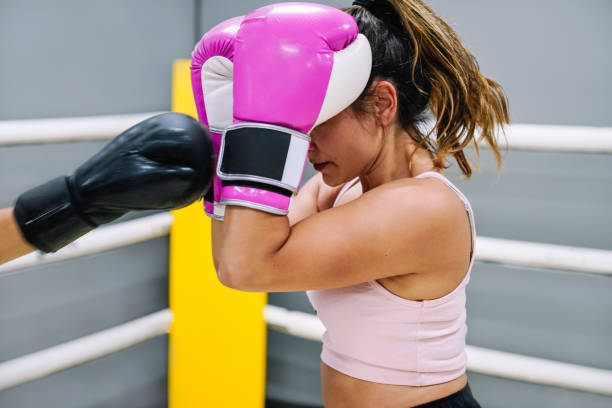 istock Female boxer protecting herself from her opponent's punches in the ring 1460478822