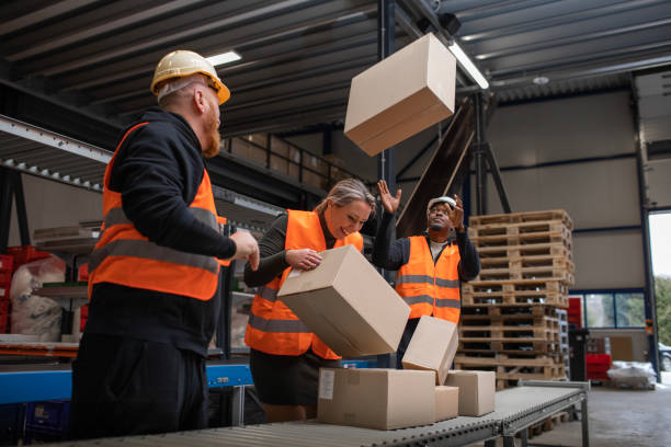 istock Three warehouse workers being irresponsible on a packing and delivery production line 1460478929